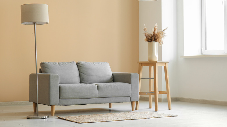 A neutral living room with a sofa and floor lamp