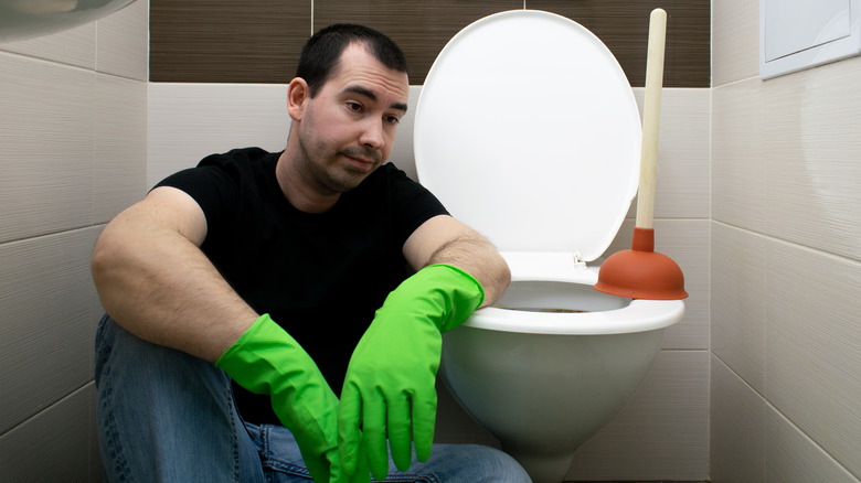 Man sitting by toilet