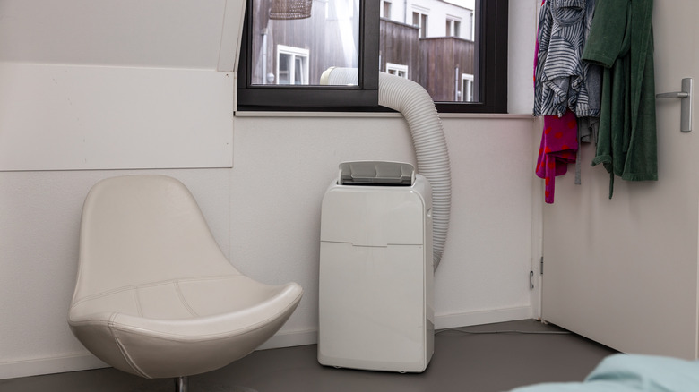 Portable AC unit with vent in a window in a small living room