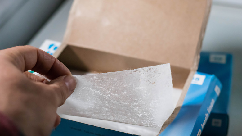 Hand picking up dryer sheet