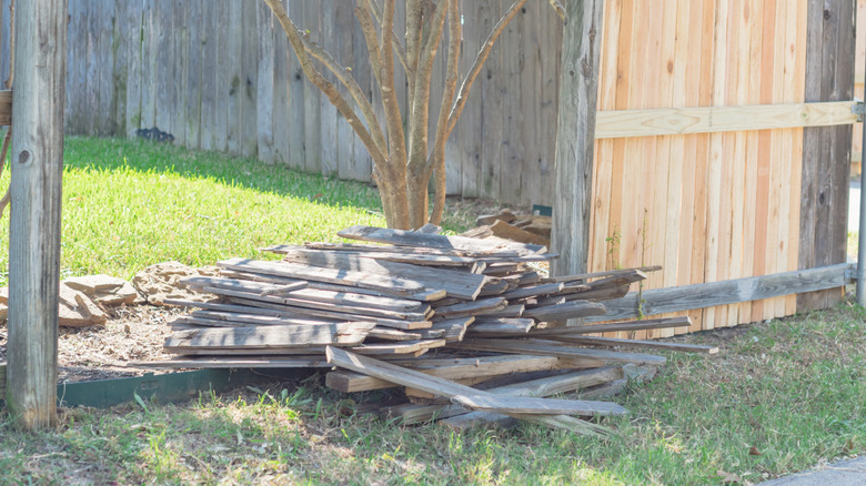 A partially deconstructed fence laying in a pile on the ground.