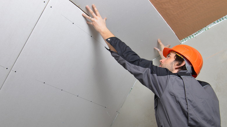 Man holding drywall up