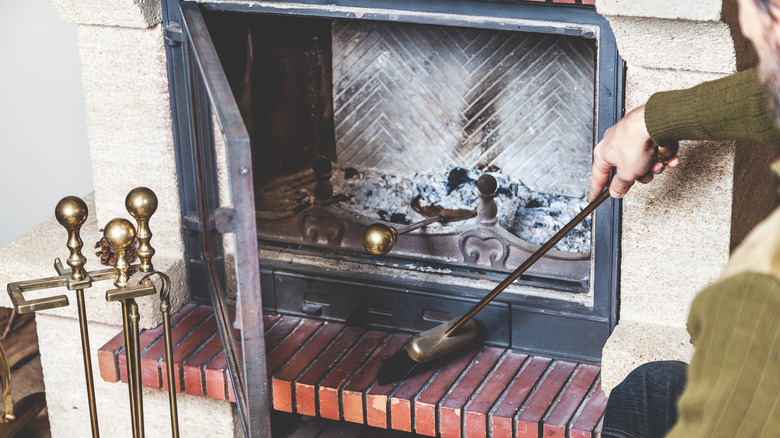 person sweeping fireplace hearth
