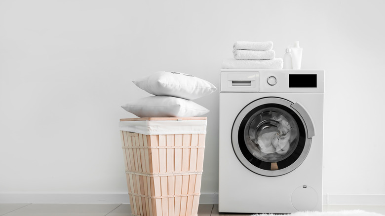 Pillows on top of hamper in laundry room
