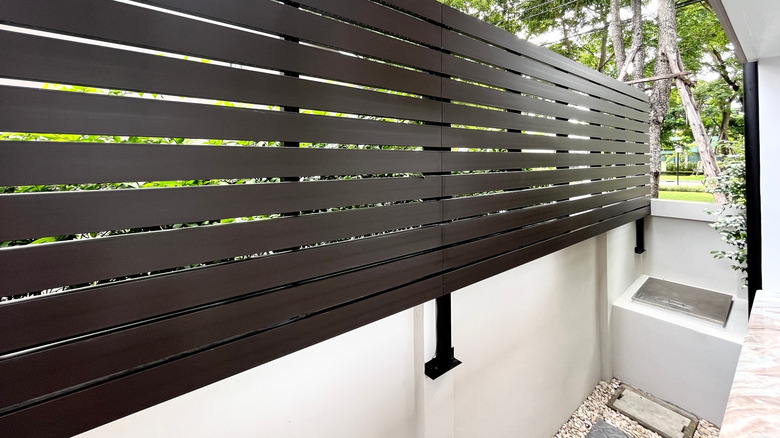 Black vinyl fence panels on a white wall