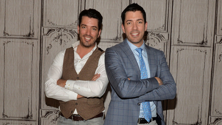 The Property Brothers posing back to back