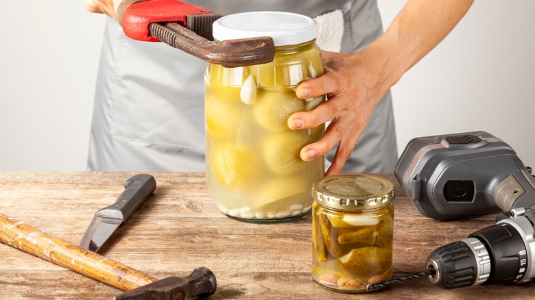 man opening jar with tools