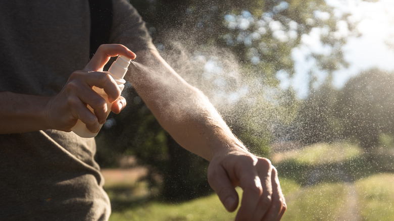 Man is applying insect repellent on his hand.