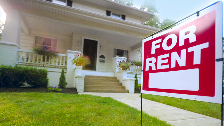 House with a For Rent sign in the front yard