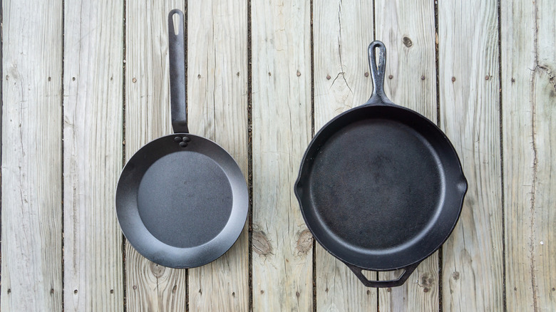 A side-by-side photo of a cast iron and carbon steel skillet