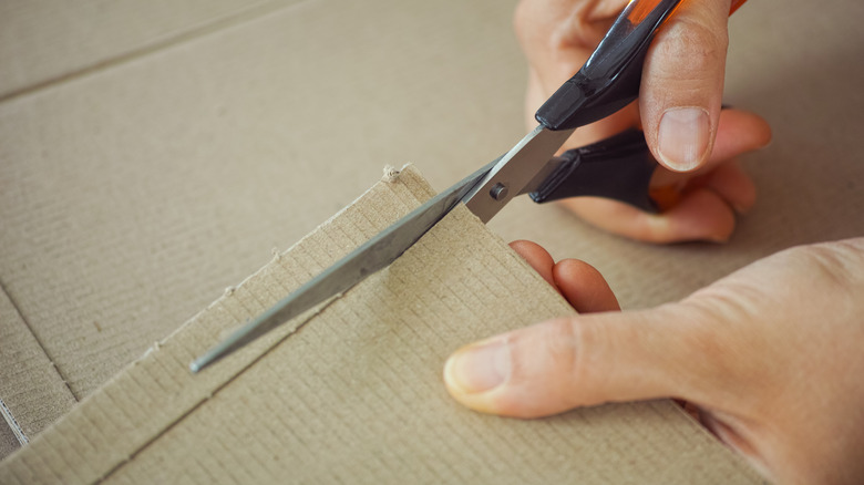 A person cutting into cardboard