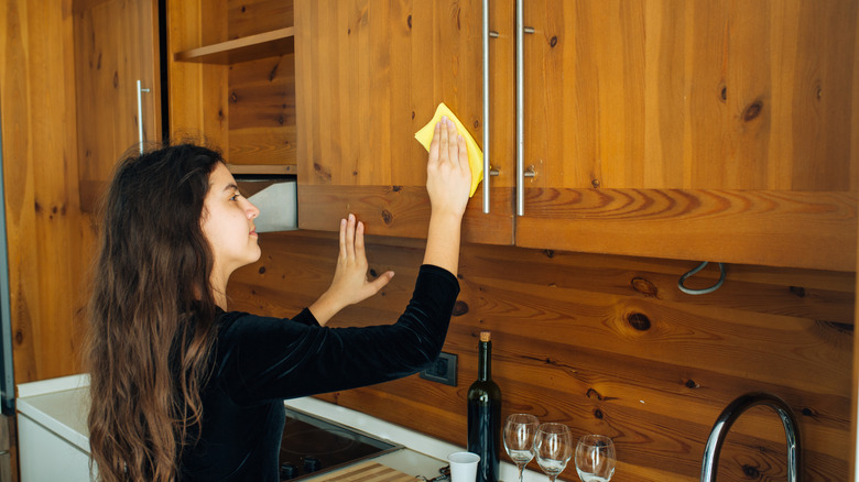 girl cleaning wood paneled kitchen