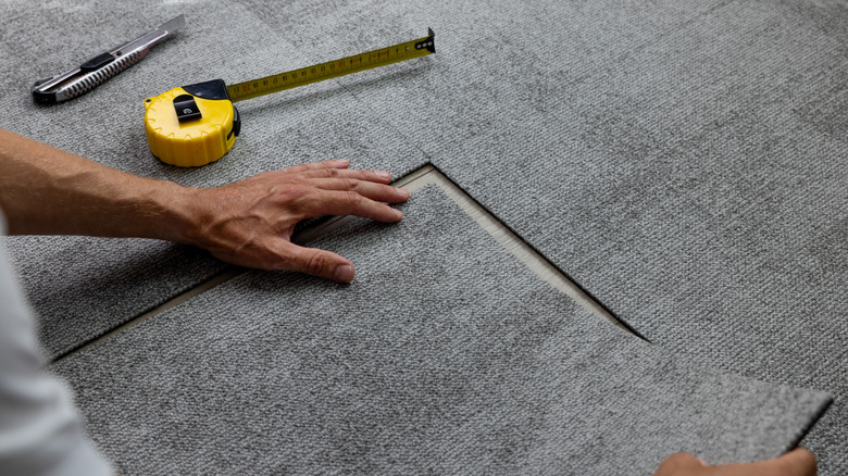 A man installing carpet tiles
