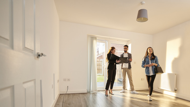 couple and realtor touring home