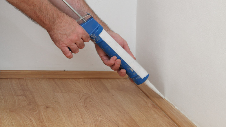 Worker caulking wall finishings