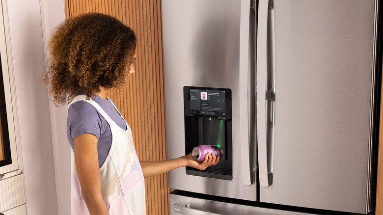 A girl scans a can of pop with the GE Profile fridge.
