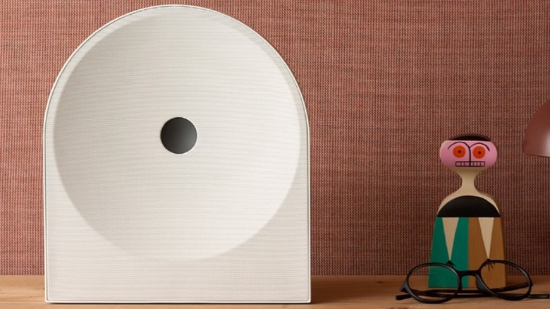 A Samsung Music Studio 5 sits on a table next to a pair of glasses and a figurine.