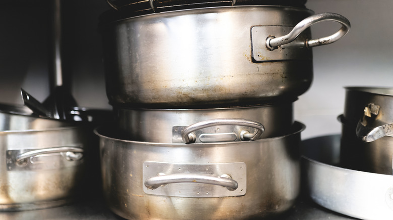 A bunch of disorganized pots in a kitchen