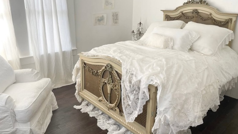 An ornate bed with layered white lace bedding