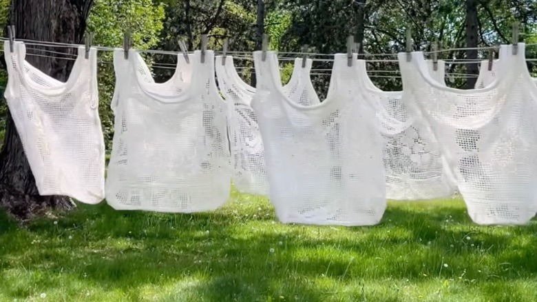 White lace tote bags hanging on a clothesline