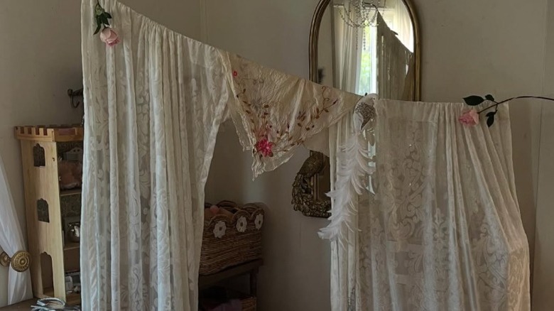 Lace curtains on a clothesline dividing off a play space in a child's room
