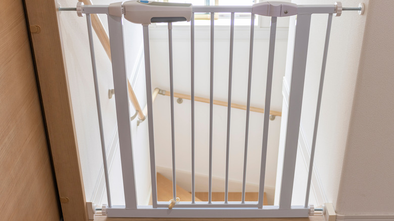 Pressure-mounted baby gate at top of stairs