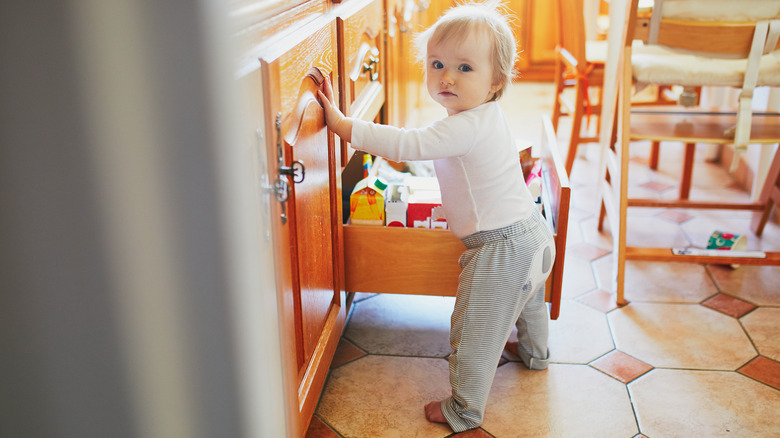Toddler with open kitchen drawer