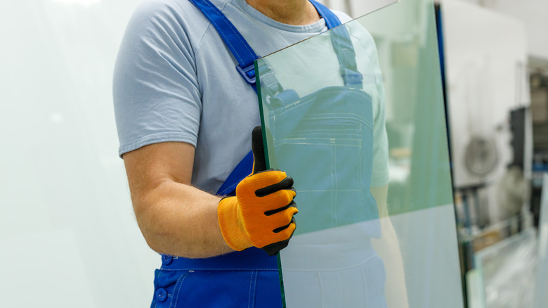 man holding glass window pane