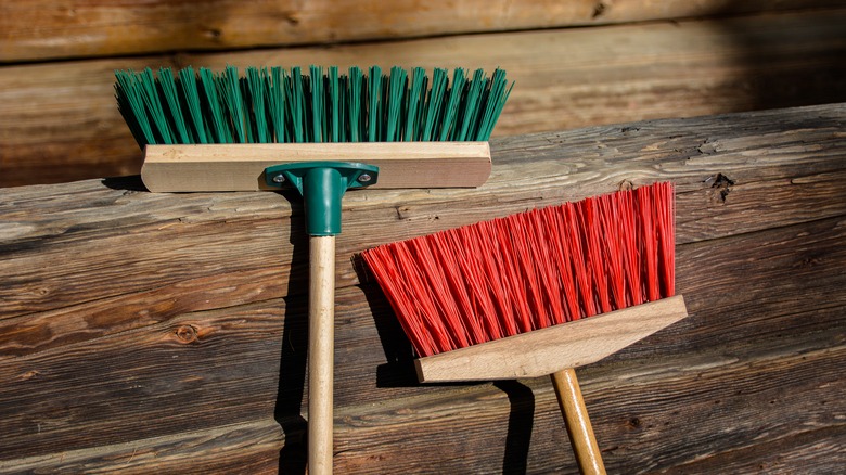 two brooms on hardwood floor