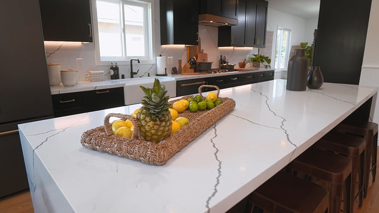 Christina Haack's trendy kitchen makeover featuring marble countertops and backsplash against dark brown kitchen cabinetry.