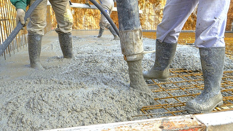 Workers pouring concrete in a frame
