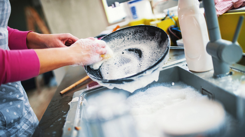 Closeup of washing a pan in the sink
