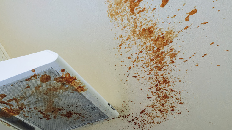 messy kitchen range hood and ceiling with grease splatters
