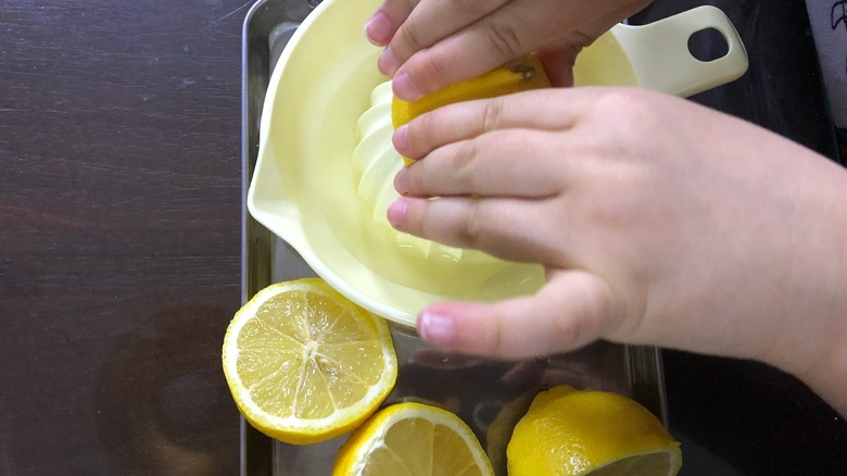 hands juicing a lemon