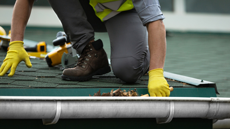 Professional cleaning a home gutter