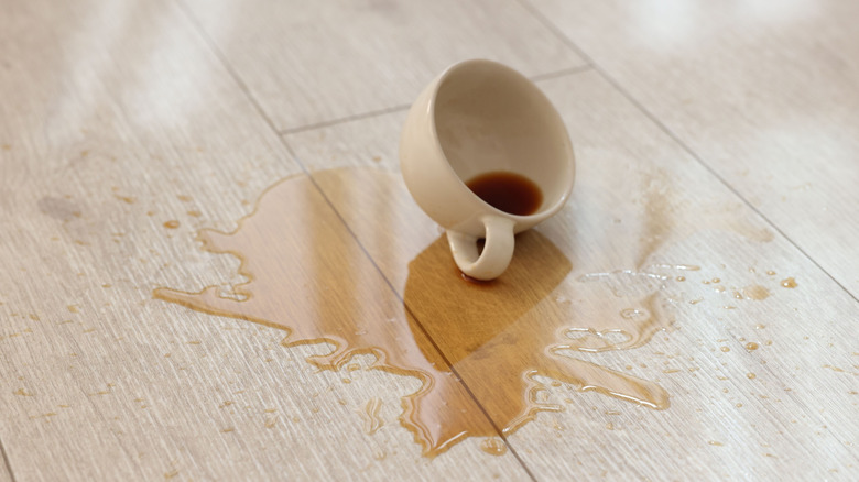 A spilled cup of coffee on a laminate floor