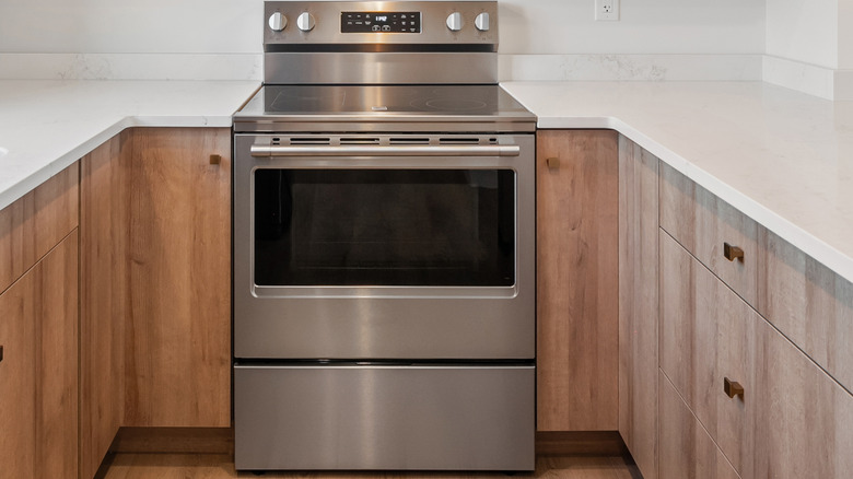 Stainless steel stove in a kitchen with wood cabinets and white countertops