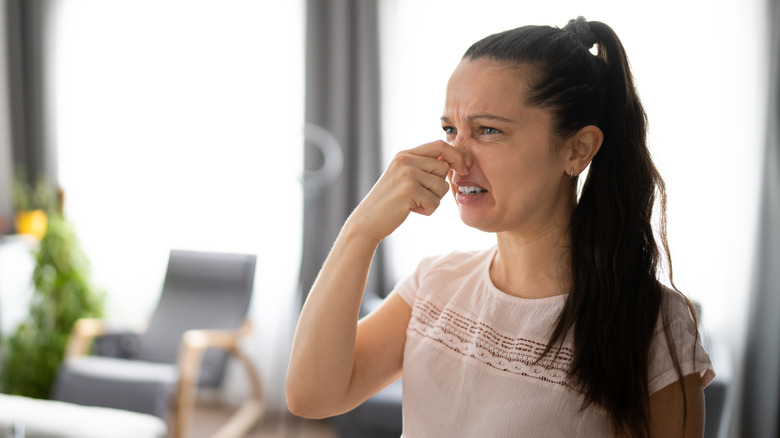 Woman holding nose 