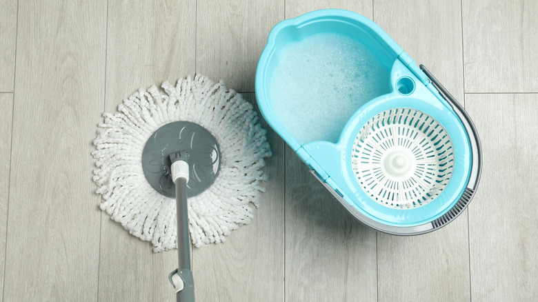 A mop and bucket with sudsy cleaning solution