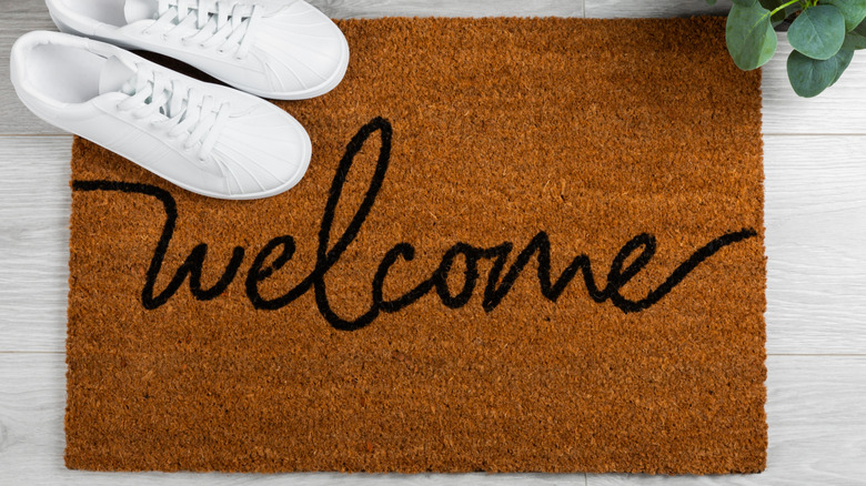 A welcome mat with shoes on a viny floor