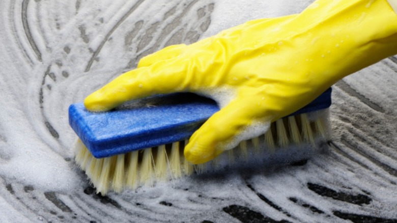 A person scubbing thef flloor with a scrubber