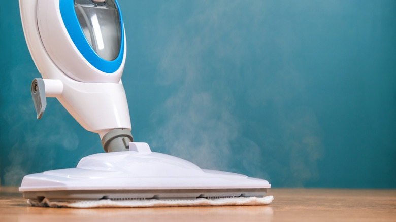A person steam cleaning a hard floor