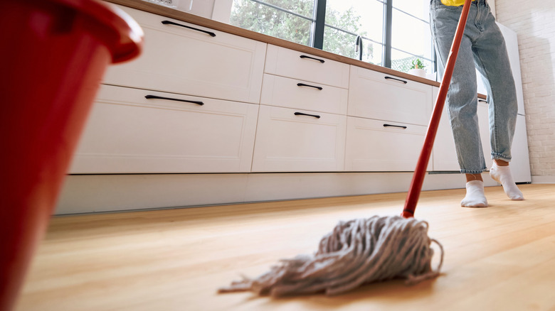A couple mopping a kitchen floor