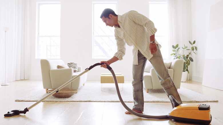 A man vacuuming the floor