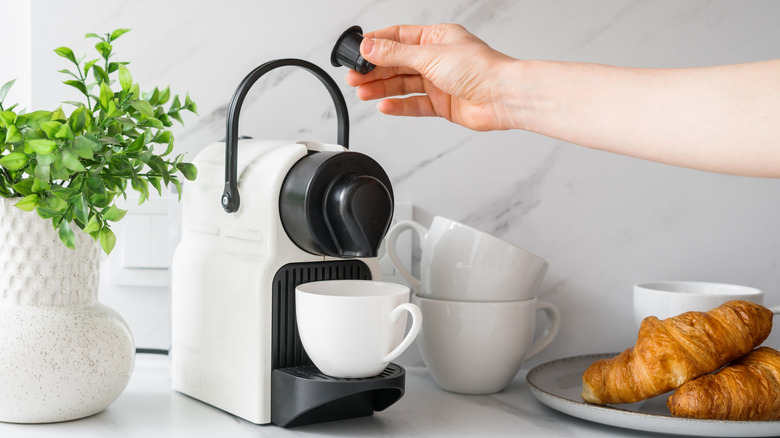 person using a coffee maker