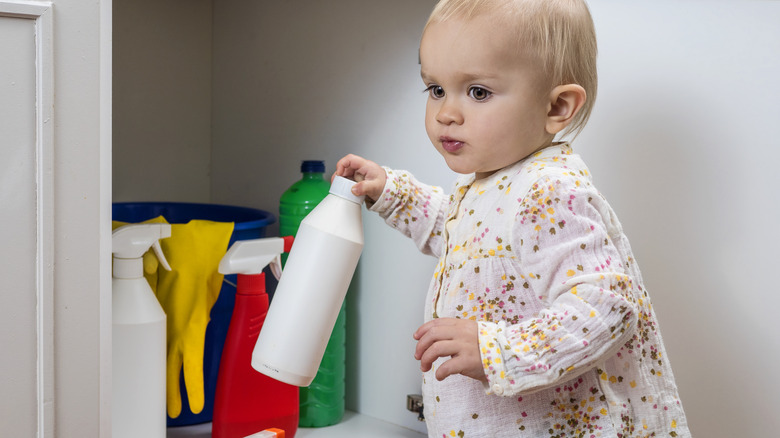 Small child with cleaning chemicals