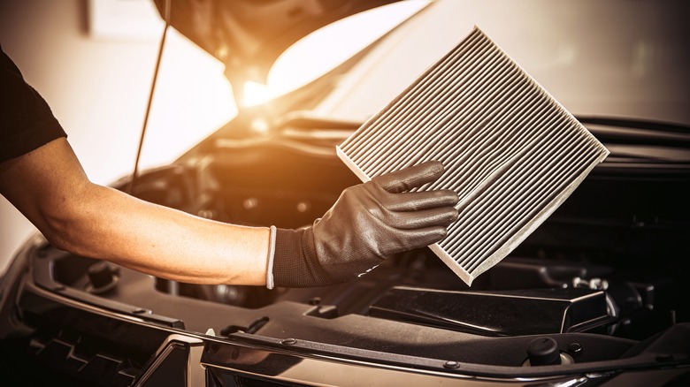 Mechanic holding car air filter