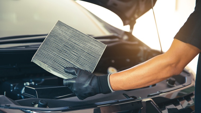 Mechanic holding car air filter