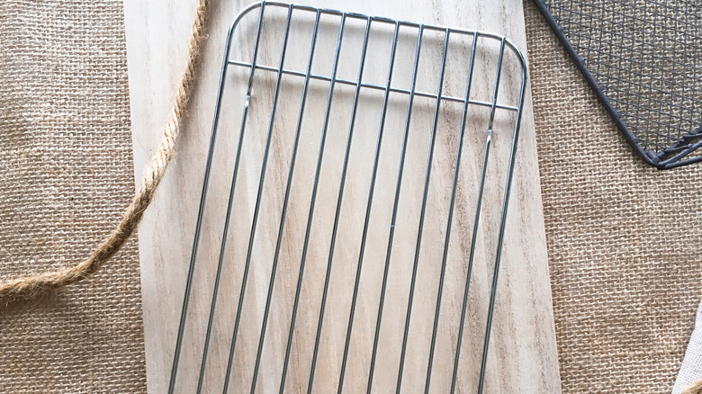 Metal cooling rack sitting out on a counter on top of a cutting board