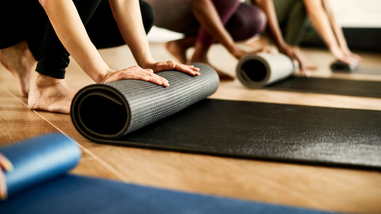 people rolling up yoga mats